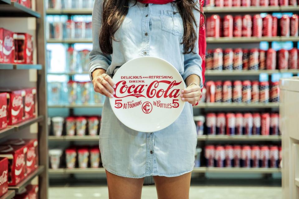 A person holds a Coca-Cola plate at a Coca-Cola store in Orlando, Florida.