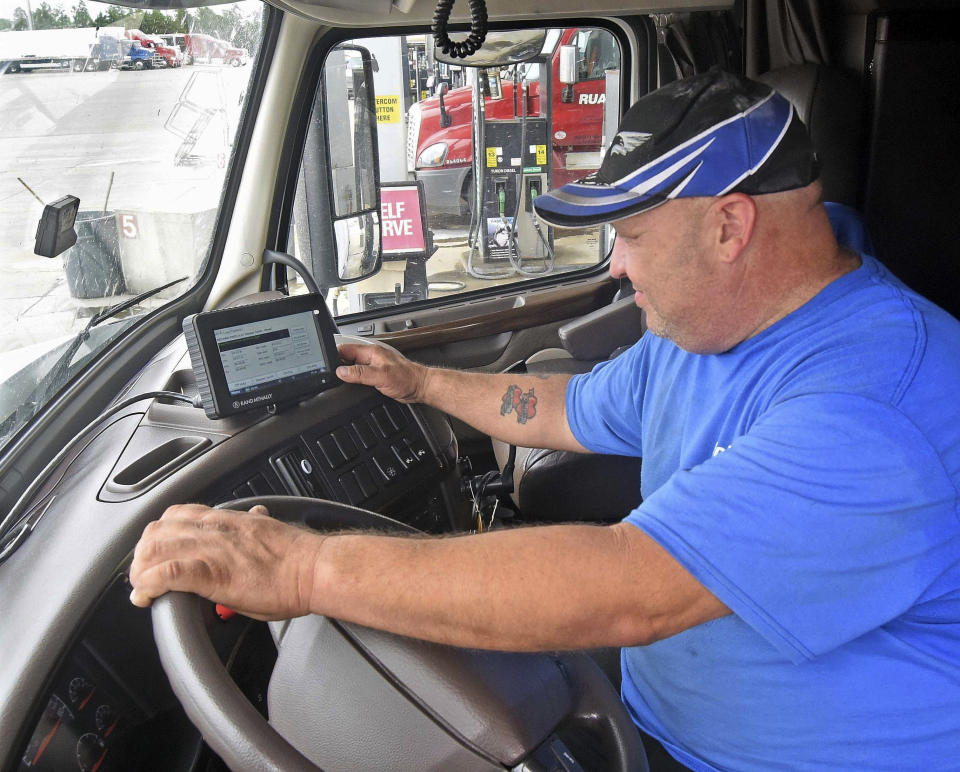 Camionero coloca datos de consumo de combustible. (Tom Stromme/The Bismarck Tribune via AP)