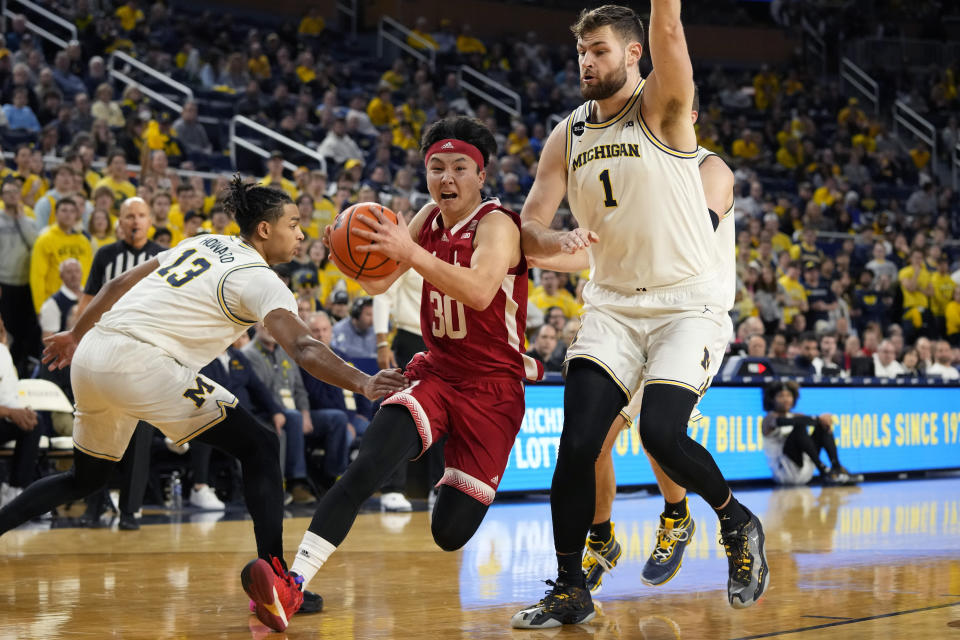 Nebraska guard Keisei Tominaga (30) drives towards the basket as Michigan guard Jett Howard (13) and center Hunter Dickinson (1) defend during the first half of an NCAA college basketball game, Wednesday, Feb. 8, 2023, in Ann Arbor, Mich. (AP Photo/Carlos Osorio)