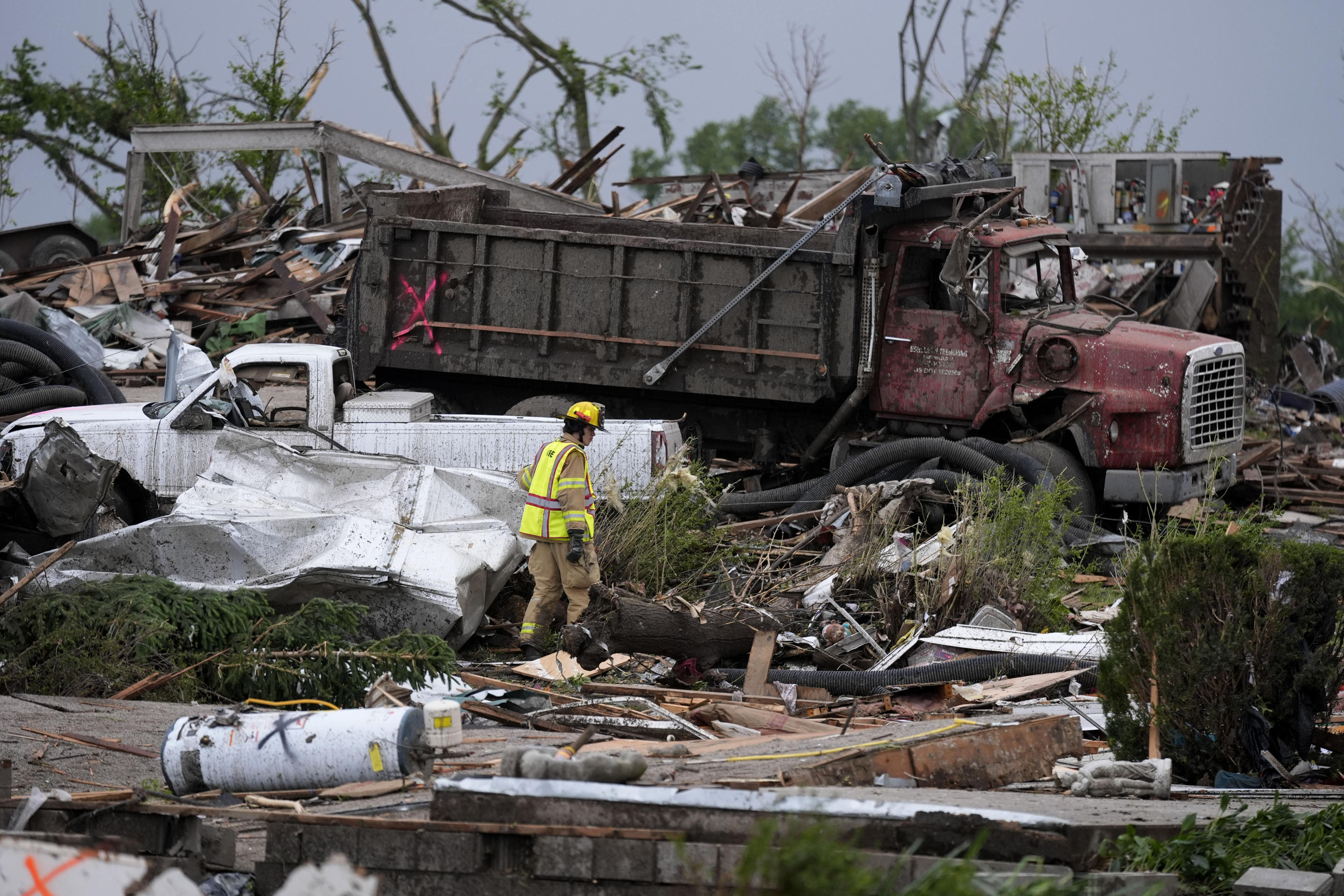 A firefighter walks among homes destroyed by a tornado on Tuesday in Greenfield, Iowa. 