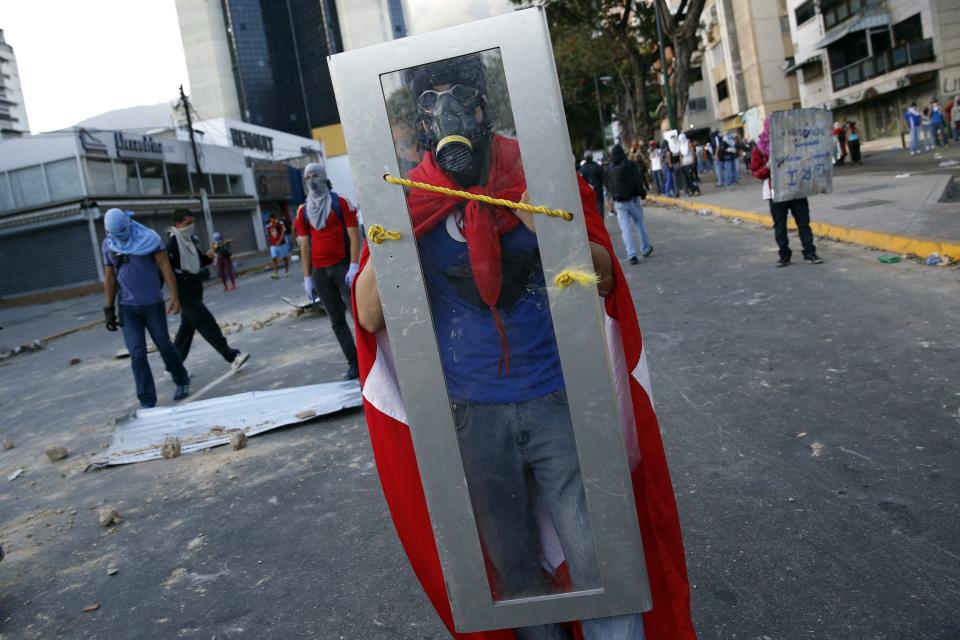 Anti-government protesters use makeshift shields during a protest against Nicolas Maduro's government in Caracas March 3, 2014. Jailed Venezuelan opposition leader Leopoldo Lopez urged sympathizers on Monday to maintain street protests against President Nicolas Maduro as the country's foreign minister prepared to meet the United Nations Secretary General. REUTERS/Carlos Garcia Rawlins