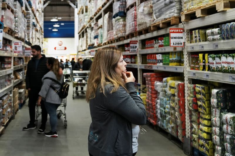 Constumers check products at a wholesaler, as Argentina is due to release consumer inflation data for April, in Buenos Aires