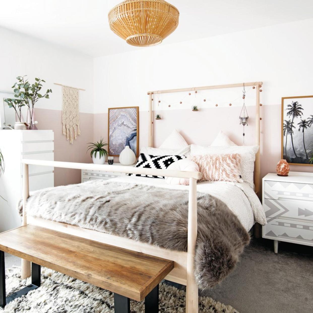  Master teenage girl bedroom with fur throw on double bed, wooden bench and pink and white walls, white and grey chests of drawers as bedside tables. hanging ornaments, fairy lights on the bedhead. . 