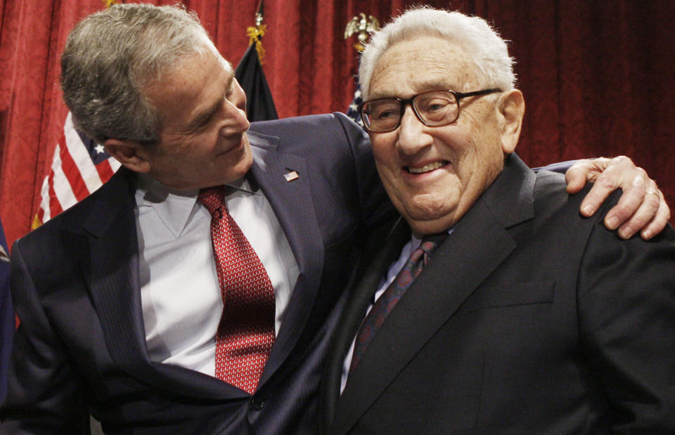 FILE - President George W. Bush, left, stands with former Secretary of State Henry Kissinger after the president spoke about the economy during an addressing before The Economic Club of New York in New York, March 14, 2008. Kissinger, the diplomat with the thick glasses and gravelly voice who dominated foreign policy as the United States extricated itself from Vietnam and broke down barriers with China, died Wednesday, Nov. 29, 2023. He was 100. (AP Photo/Charles Dharapak, File)