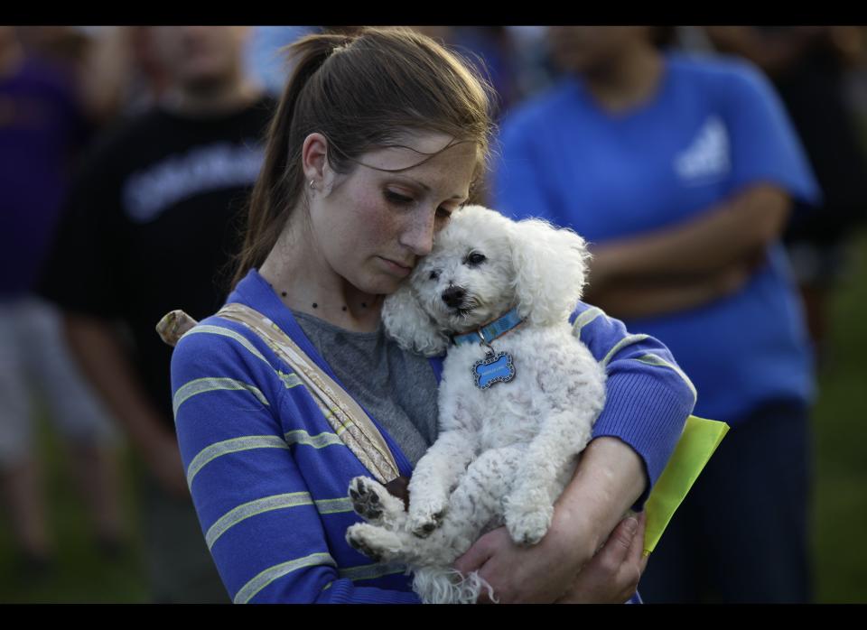 2012년 7월 22일 콜로라도주 오로라시 A woman hugs her dog during a memorial outside the Aurora Municipal Center July 22, 2012 in Aurora, Colorado.  (Photo by Joshua Lott/Getty Images)