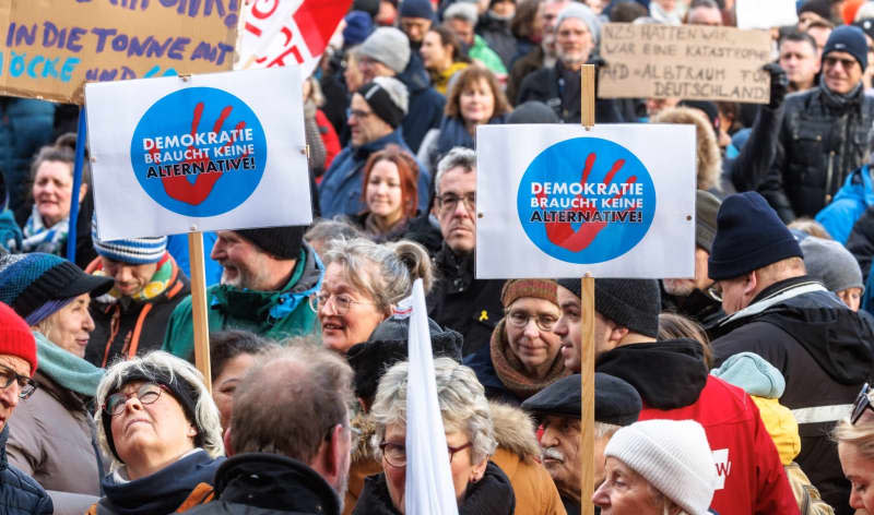 Demonstrators hold signs reading "Democracy needs no alternative!" at a rally organized by the German Trade Union Confederation (DGB) on "For democracy and solidarity". Markus Scholz/dpa