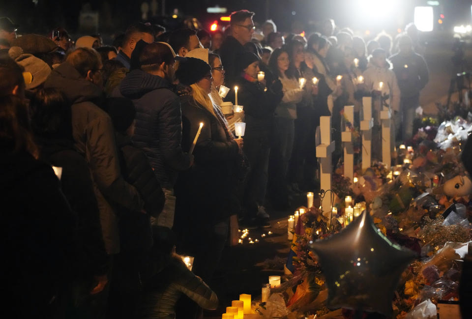 Mourners hold candles during a vigil at a makeshift memorial to mark the weekend mass shooting at a gay bar, late Monday, Nov. 21, 2022, in Colorado Springs, Colo. (AP Photo/David Zalubowski)