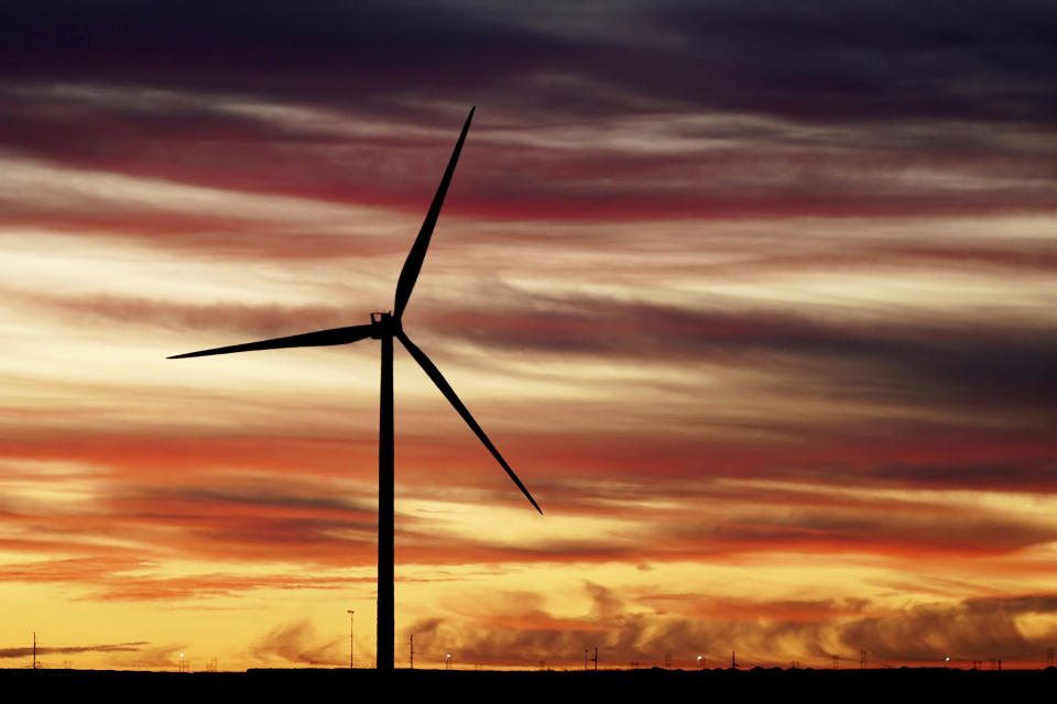 The sun rises behind a windmill before President Joe Biden's visit to CS Wind, the world's largest facility for wind tower manufacturing, Wednesday, Nov. 29, 2023, in Pueblo, Colo. (AP Photo/Jack Dempsey)