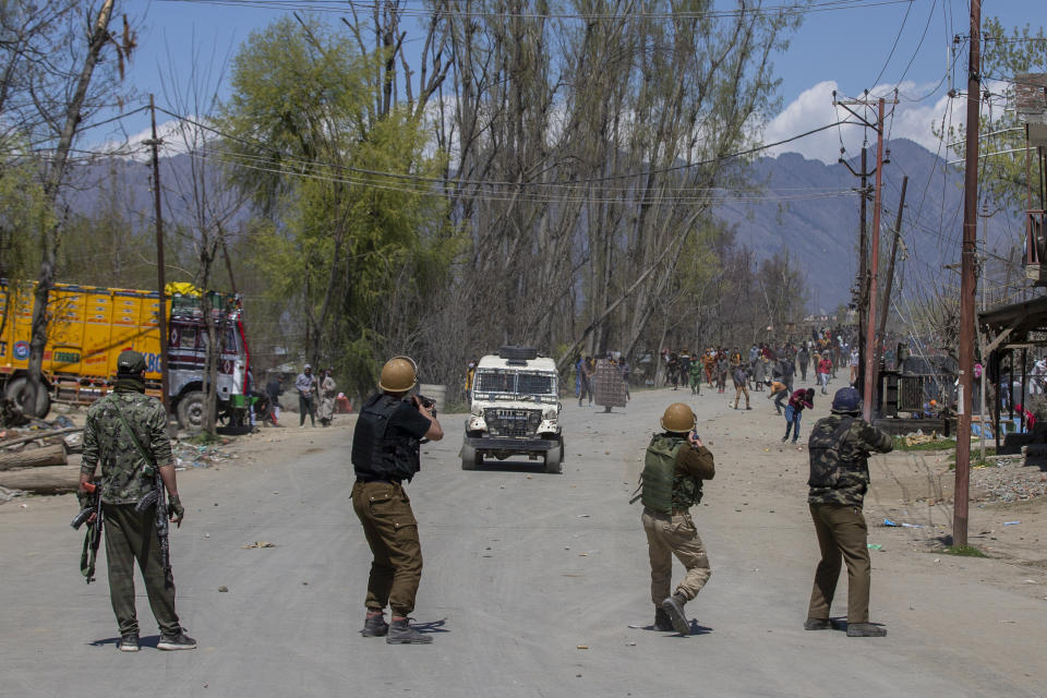 Indian policemen fire pellets at Kashmiri villagers during a protest near the site of a gunbattle in Pulwama, south of Srinagar, Indian controlled Kashmir, Friday, April 2, 2021. Anti-India protests and clashes have erupted between government forces and locals who thronged a village in disputed Kashmir following a gunbattle that killed three suspected militants. Police say the gunfight on Friday erupted shortly after scores of counterinsurgency police and soldiers launched an operation based on tip about presence of militants in a village in southern Pulwama district. (AP Photo/ Dar Yasin)