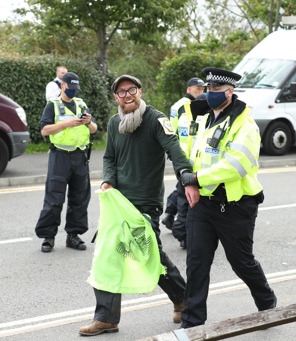 One of the protesters from the bamboo lock-ons is lead away by a police officer at Broxbourne, Hertfordshire.