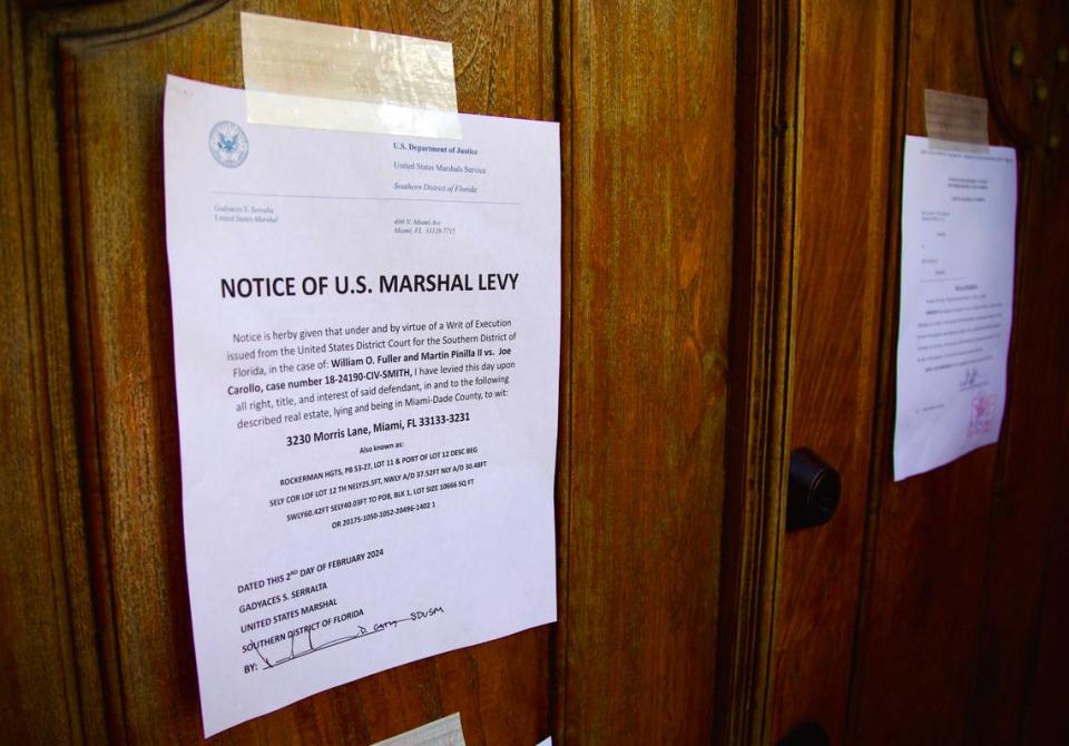 Notices posted on the front door to Joe Carollo’s residence in Coconut Grove after posting notices on Friday, Feb. 2, 2024. U.S. Marshals are moving to seize the property of the Miami commissioner after he lost a civil trial accusing him of misusing his public office.