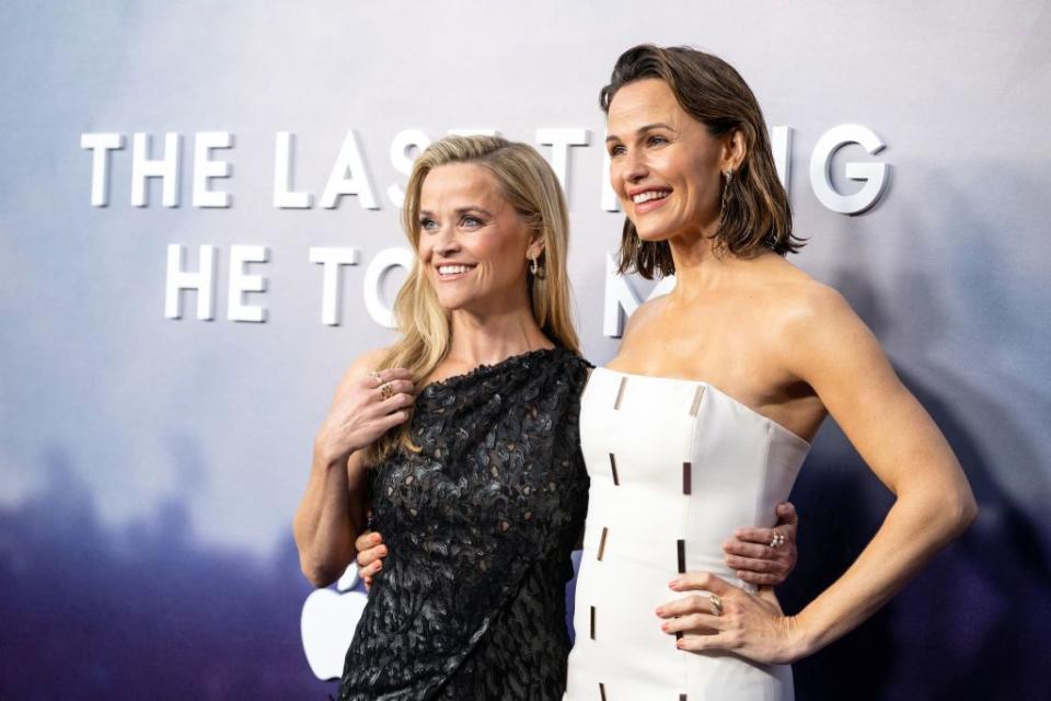 jennifer garner in white strapless dress poses with reese witherspoon in black sequin one shoulder dress