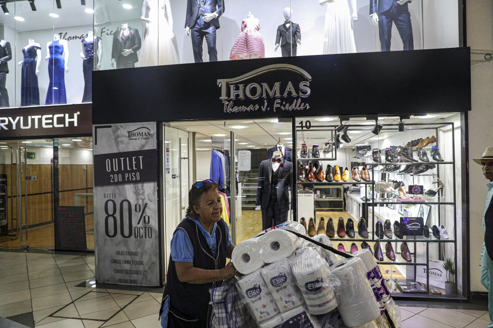 In this Nov. 5, 2019 photo, retired Maria Gonzalez, 77, works selling tissue and toilet paper in downtown Santiago, Chile. Reforms to Chile’s dictatorship-era pension system has emerged as one of the key demands of the massive mobilizations that continue to consume the South American nation. (AP Photo/Esteban Felix)