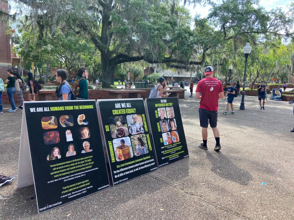 Students walk by anti-abortion displays from Created Equal in UF's Turlington Plaza on March 10, 2023.