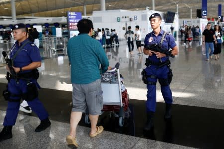 Armed police patrol the departure hall of the airport in Hong Kong after previous night's clashes with protesters