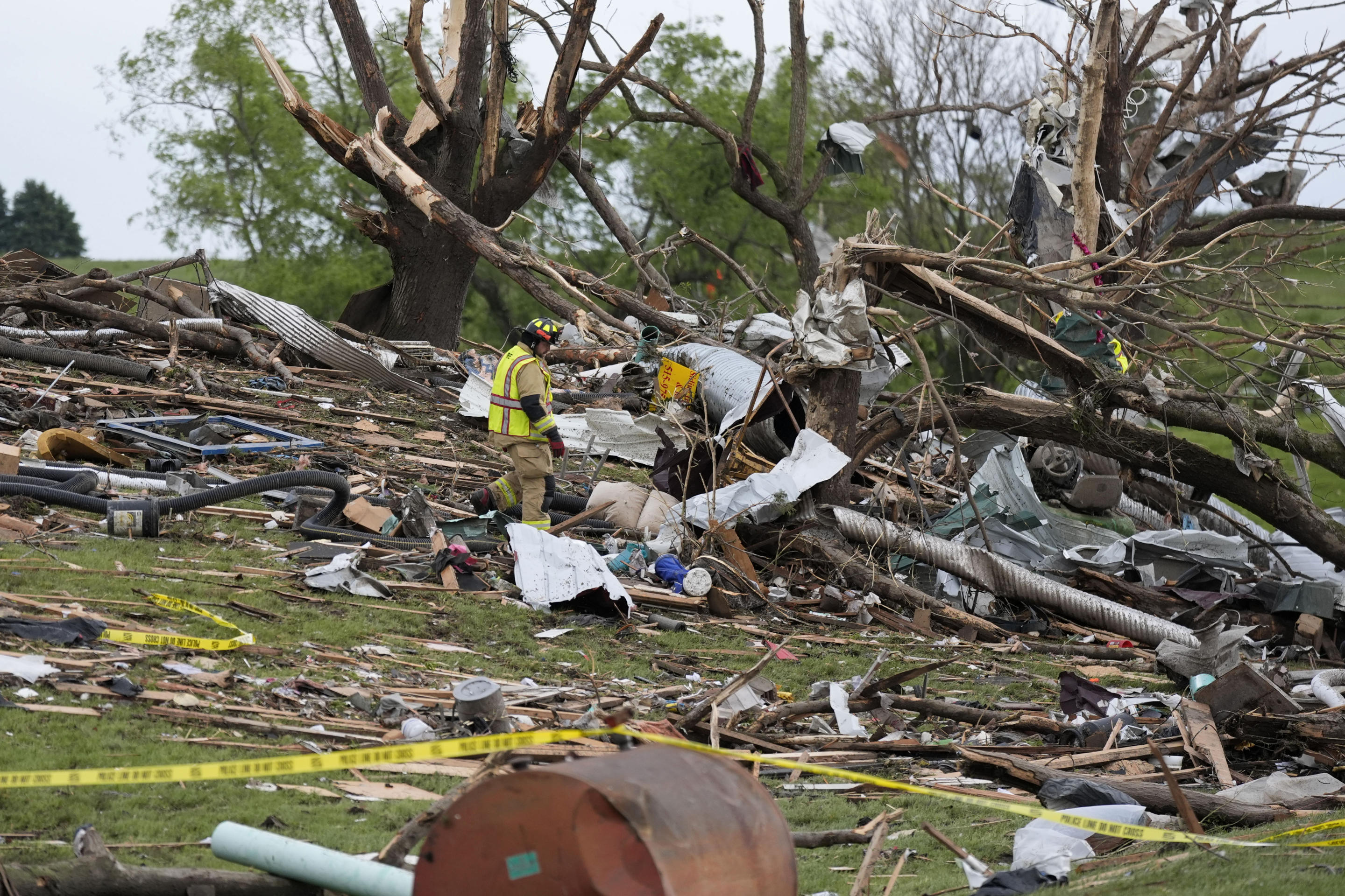 A firefighter searches through the remains of tornado-damaged property on Tuesday in Greenfield, Iowa.