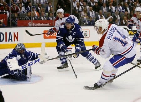 Oct 7, 2015; Toronto, Ontario, CAN; Montreal Canadiens forward Tomas Plekanec (14) gets off a shot on Toronto Maple Leafs goaltender Jonathan Bernier (45) as defenceman Dion Phaneuf (3) looks on at the Air Canada Centre. John E. Sokolowski-USA TODAY Sports