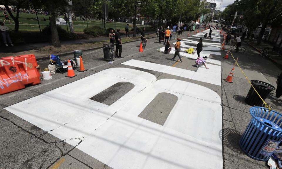 People work to dry off large letters that read ‘Black Lives Matter’ in the area.