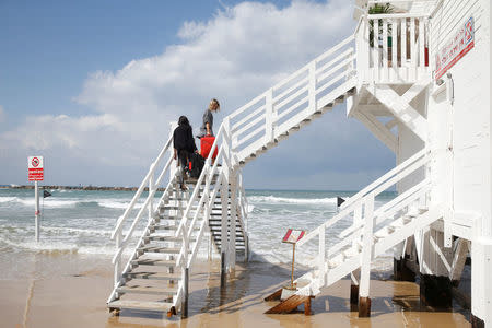 Winners of an international online competition, German bloggers Sandra Lechner and Izabella Meczykowska, carry their suitcases up the stairs of a lifeguard tower, upon arriving to spend the night at the tower which has been renovated into a luxury hotel suite, at Frishman Beach in Tel Aviv, Israel March 14, 2017. REUTERS/Baz Ratner