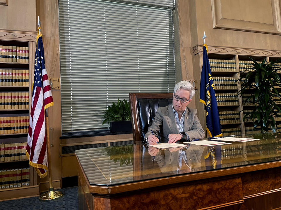 Newly sworn-in Oregon Gov. Tina Kotek signs three executive orders to combat homelessness at the State Library of Oregon in the state capital Salem on Tuesday, Jan. 10, 2023, her first full day in office. The executive orders declared a homeless emergency in most of the state, increased housing construction targets, and directed state agencies to prioritize reducing homelessness. (AP Photo/Claire Rush)