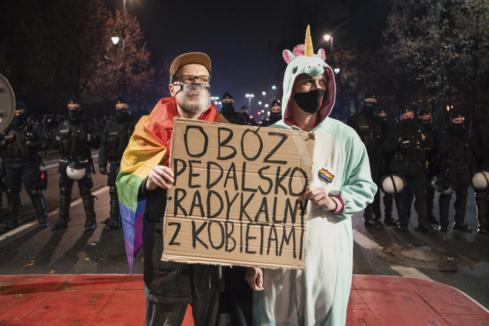 Demonstrators hold a banner that reads "Gay Radical Camp Stands With Women" during a protest against a top court ruling restricting abortions in Warsaw, Poland, Wednesday, Nov. 18, 2020. Before the court ruling, the people on the front lines of Poland's culture war had been LGBT rights activists who were frequently denounced by government and church leaders as a threat to Poland's culture and families. Those grievances have now been woven together into one larger struggle against a government that the protesters hope to eventually bring down.(AP Photo/Agata Grzybowska)