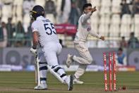 Pakistan's Abrar Ahmed, right, celebrates after taking wicket of England's Ben Stokes, left, during the first day of the second test cricket match between Pakistan and England, in Multan, Pakistan, Friday, Dec. 9, 2022. (AP Photo/Anjum Naveed)