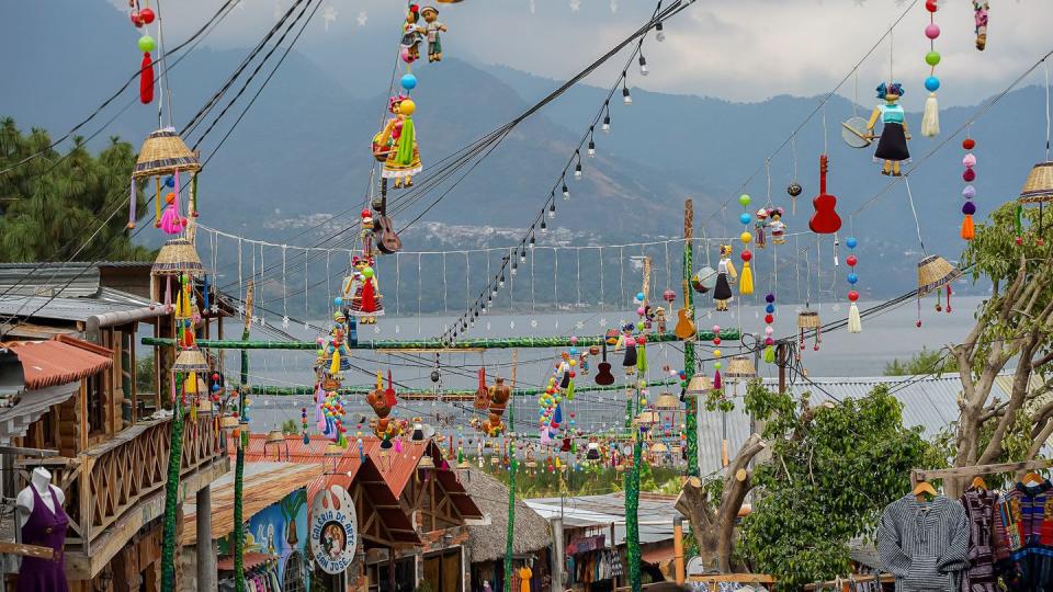 beautiful aerial view of san juan la laguna small town in the guatemala atitlan lake umbrella streets, colorful people and tourists