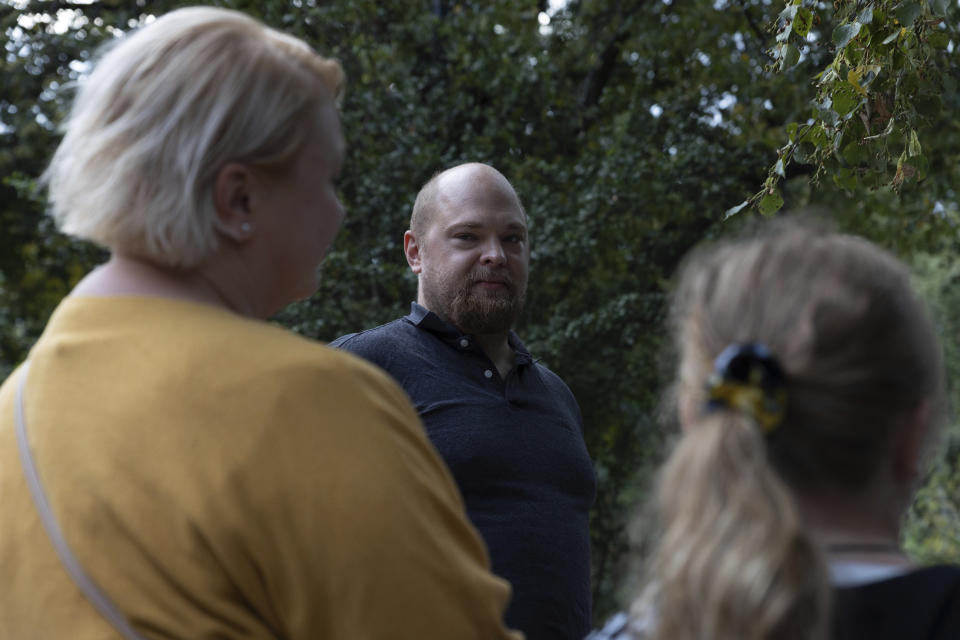 Piotr Polatynski looks at his wife, left, and daughter, right, during an interview with The Associated Press in Warsaw, Poland, Wednesday, Aug. 31, 2022. The public schools in Poland are facing a shortage of teachers, a problem that is growing increasingly serious each year as people leave the profession over low wages and policies of a government which they fear does not value them. A teachers union and teachers say the situation threatens the education of the country's youth, though the government insists that they are exaggerating the scale of the problem. (AP Photo/Michal Dyjuk)