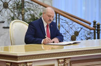 Belarusian President Alexander Lukashenko signs the inauguration certificate during his inauguration ceremony at the Palace of the Independence in Minsk, Belarus, Wednesday, Sept. 23, 2020. Lukashenko of Belarus has assumed his sixth term of office in an inauguration ceremony that wasn't announced in advance. State news agency BelTA reports that the ceremony will take place with several hundred top government official present. (Andrei Stasevich/Pool Photo via AP)