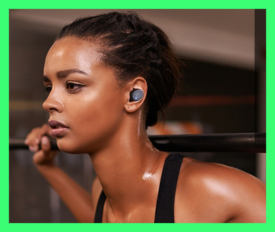 Woman wearing Tozo Wireless earbuds while lifting weights.