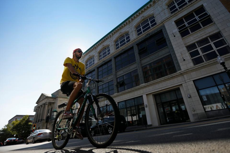 A man rides his bicycle up Union Street in New Bedford past the Star Store building downtown.