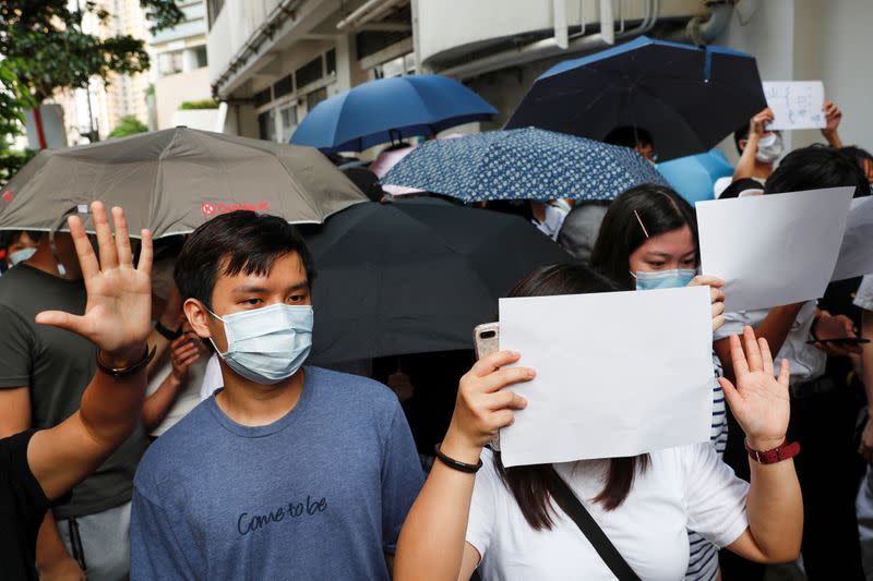 FILE PHOTO: Supporters raise white paper to avoid slogans banned under the national security law as they support arrested anti-law protesters outside the Eastern Court in Hong Kong