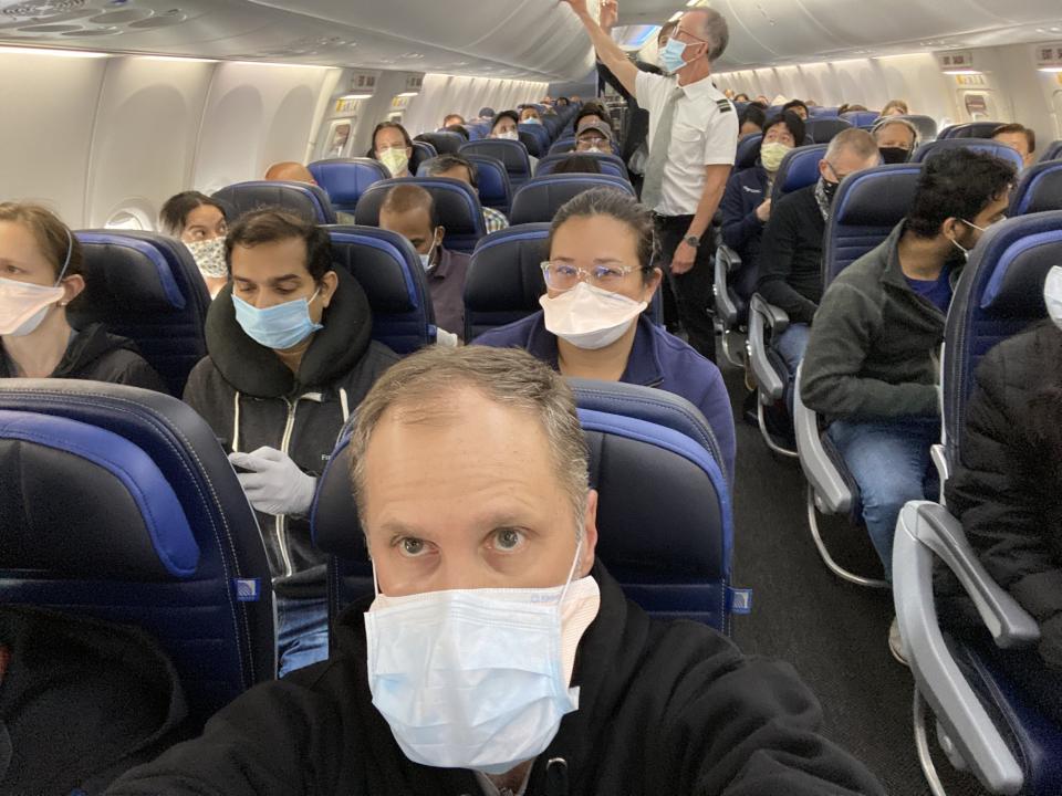 A packed United Airlines flight is pictured with Ethan Weiss seated.