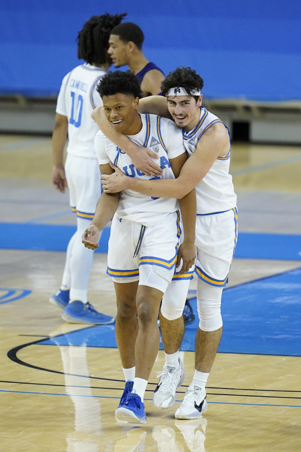UCLA guard Jaylen Clark, front left, and guard Jaime Jaquez Jr., right, celebrate their win over Washington after an NCAA college basketball game Saturday, Jan. 16, 2021, in Los Angeles. (AP Photo/Ashley Landis)