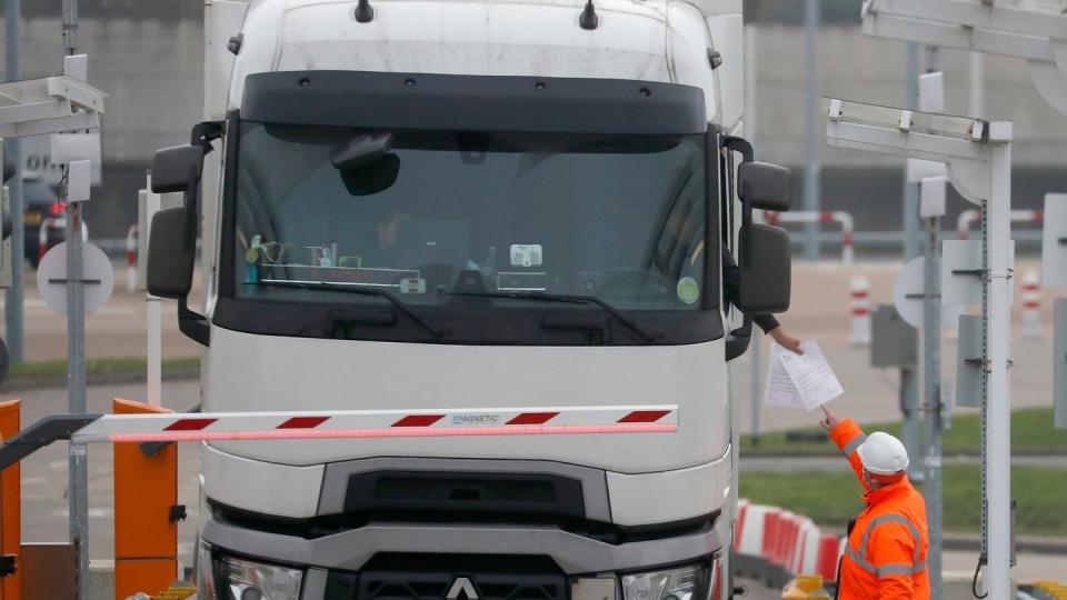 Die Dokumente eines Lastwagenfahrers werden kontrolliert, als der Lkw den Check-in für den Zug durch den Eurotunnel passiert.