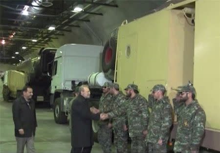 Iran's parliament speaker Ali Larijani shakes hands with a soldier as he inaugurates a new underground missile depot in this undated handout photo released January 5, 2016 by Farsnews.com. REUTERS/farsnews.com/Handout via Reuters