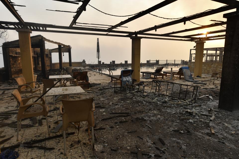 A burnt hotel during a wildfire in Lalas village, near Olympia town, western Greece, Thursday, Aug. 5, 2021. Wildfires rekindled outside Athens and forced more evacuations around southern Greece Thursday as weather conditions worsened and firefighters in a round-the-clock battle stopped the flames just outside the birthplace of the ancient Olympics. (Giannis Spyrounis/ilialive.gr via AP)