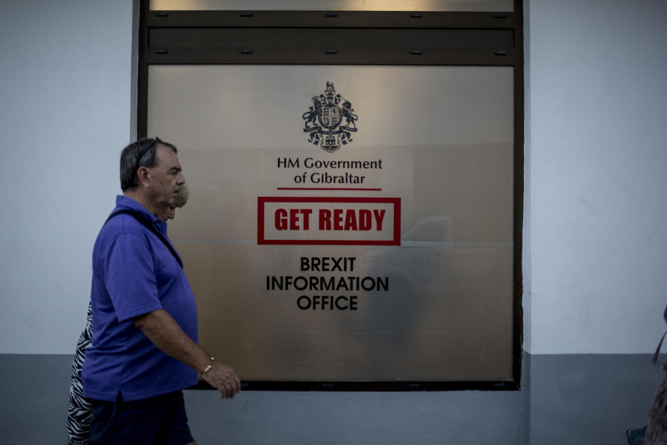 People walk past a Brexit information office during general elections in Gibraltar, Thursday Oct. 17, 2019. An election for Gibraltar's 17-seat parliament is taking place Thursday under a cloud of uncertainty about what Brexit will bring for this British territory on Spain's southern tip.(AP Photo/Javier Fergo)