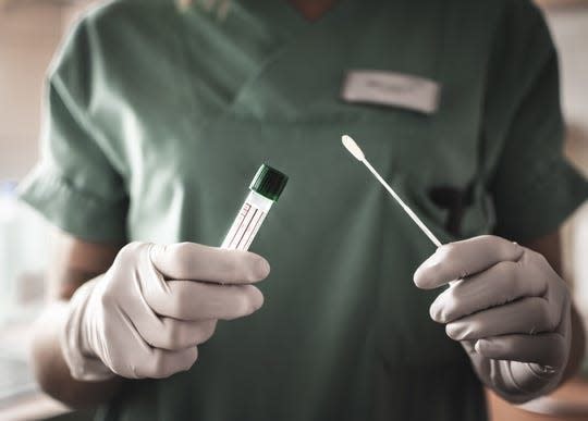 A nurse holds a swab for the coronavirus/COVID-19 test.