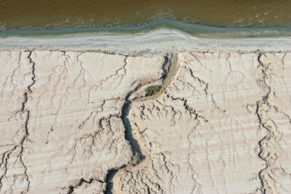 Natural washes created by rains cut patterns into the dry receding shoreline of the Salton Sea.