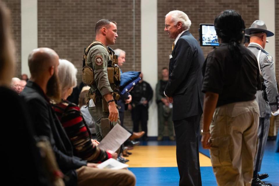State Law Enforcement Division Special Agent Richard Hunton III is given flags from South Carolina Governor Henry McMaster during a funeral for police K-9 Rico, who was killed last week while tracking a suspect. SLED agents who spoke at the funeral say Rico’s actions saved the lives of several human officers.