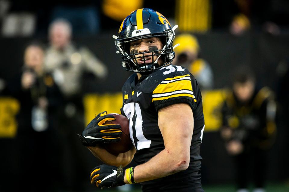 Iowa linebacker Jack Campbell (31) looks back to the bench after running an interception for a touchdown during a NCAA Big Ten Conference football game against Illinois, Saturday, Nov. 20, 2021, at Kinnick Stadium in Iowa City, Iowa.
