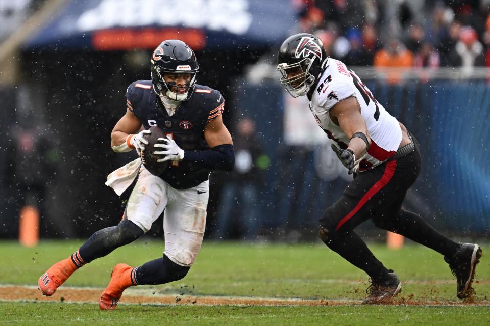 Dec 31, 2023; Chicago, Illinois, USA; Chicago Bears quarterback Justin Fields (1) scrambles away from Atlanta Falcons defensive lineman Calais Campbell (93) in the first half at Soldier Field. Mandatory Credit: Jamie Sabau-USA TODAY Sports