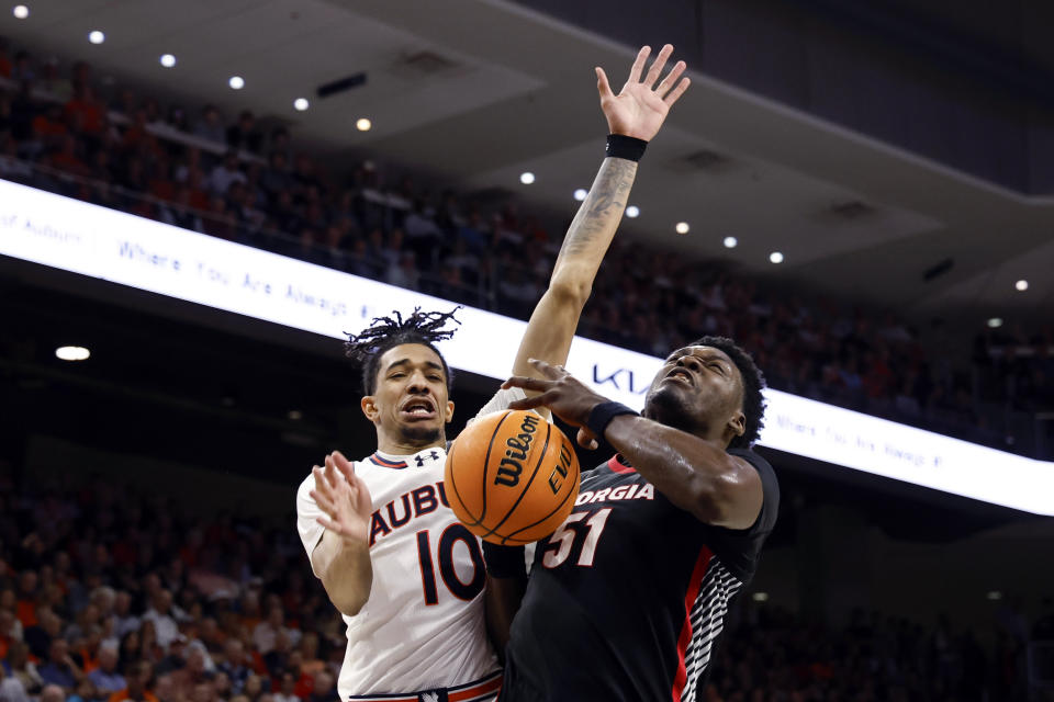 Georgia center Russel Tchewa (51) is fouled by Auburn guard Chad Baker-Mazara (10) during the first half of an NCAA college basketball game Saturday, March 9, 2024, in Auburn, Ala. (AP Photo/ Butch Dill)