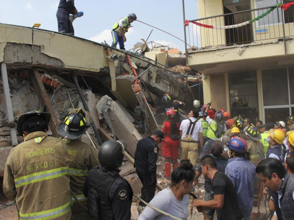 Rescue workers search for children trapped inside the collapsed Enrique Rebsamen school in Mexico City (Carlos Cisneros/AP)