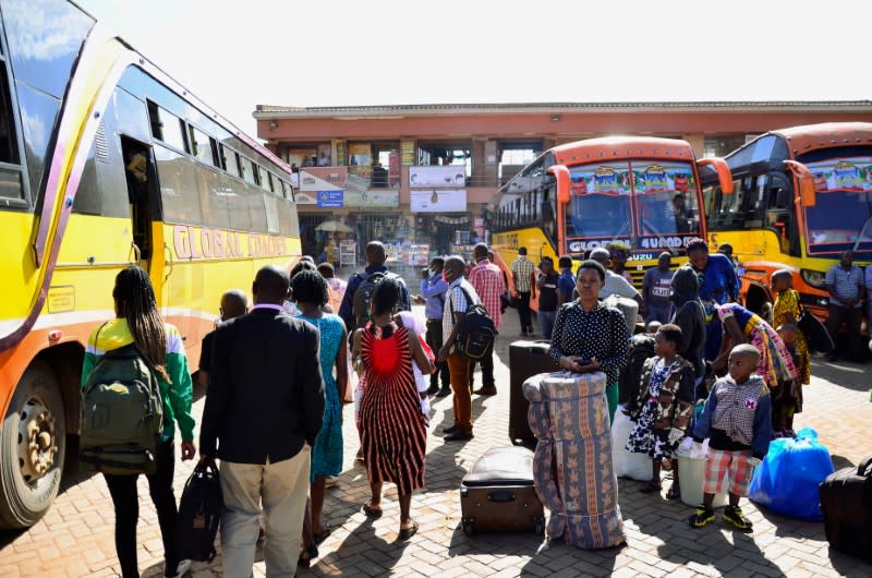 Passengers gather to board public transport buses as residents leave for the villages amid concerns over the spread of coronavirus disease (COVID-19) at a bus terminal in Old Kampala