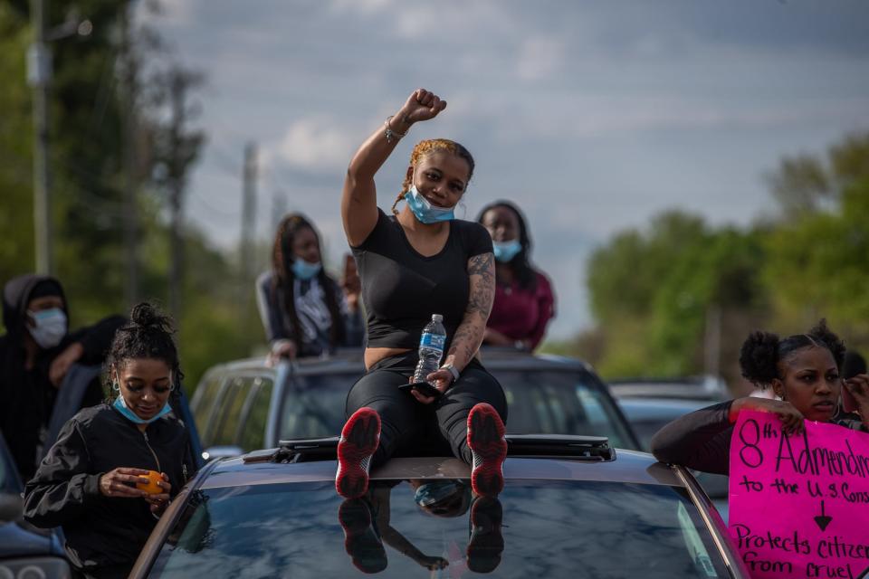 Deja Morse sits on the roof of a car during a community vigil and protest on Thursday, May 7, 2020. She was killed in a shooting at JD's Pub on April 2, 2022.