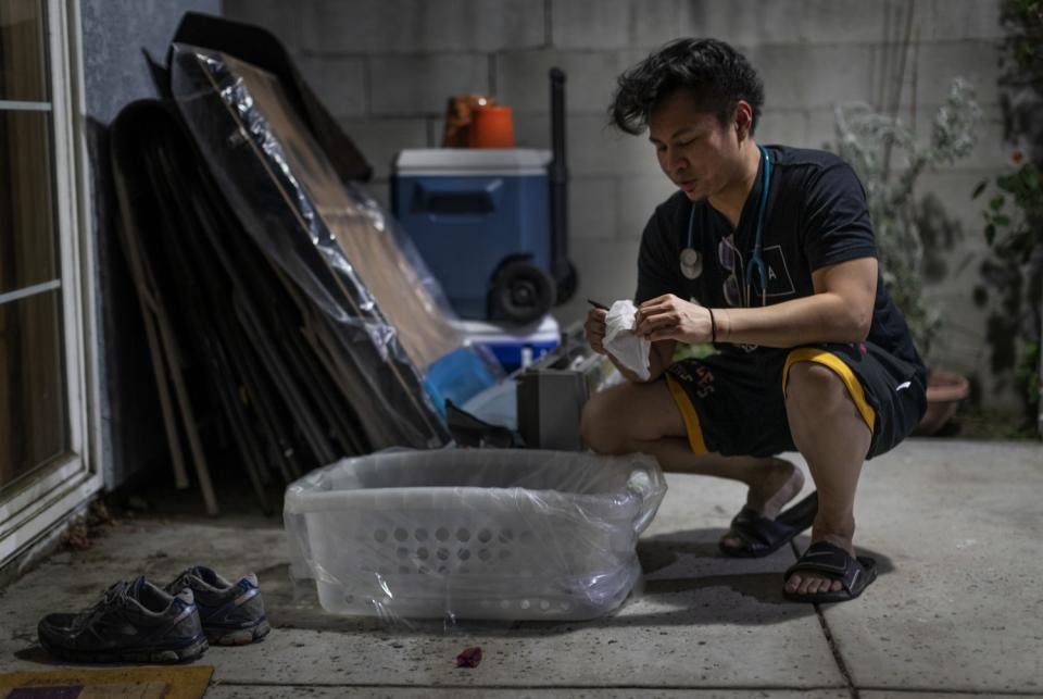 Nurse Justin Foronda disinfects his belongings in the backyard of his L.A. home as a precaution against the coronavirus.