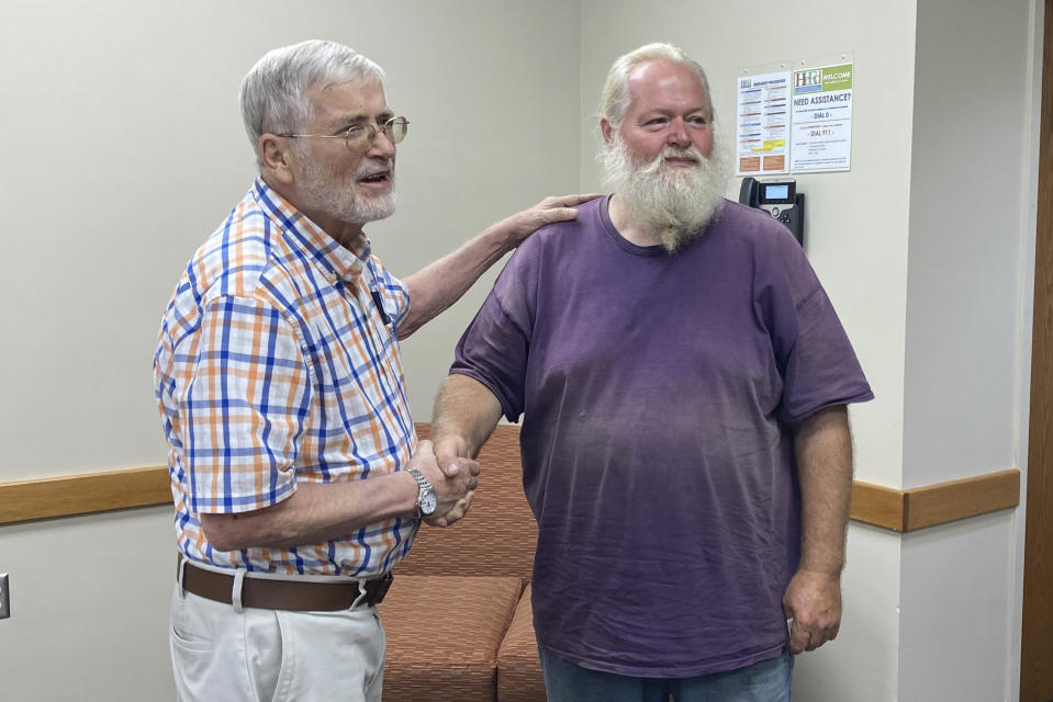 Ernest Ray, right, shakes the hand of his attorney Hugh O'Donnell, at the Virginia Higher Education Center in Abington Va., Tuesday Aug. 17, 2021. Ray has been fighting the state of Virginia in court as it tries to recoup unemployment benefits he received after being laid off from his job of more than two decades. (AP Photo/Sarah Rankin)