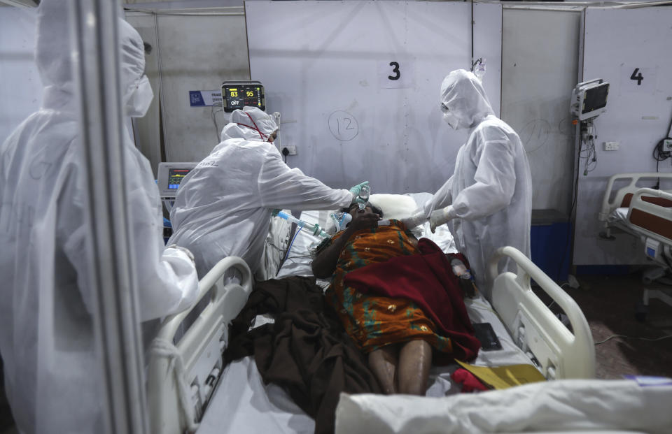 Health workers give water to a patient at the BKC jumbo field hospital, one of the largest COVID-19 facilities in Mumbai, India, Thursday, May 6, 2021. (AP Photo/Rafiq Maqbool)